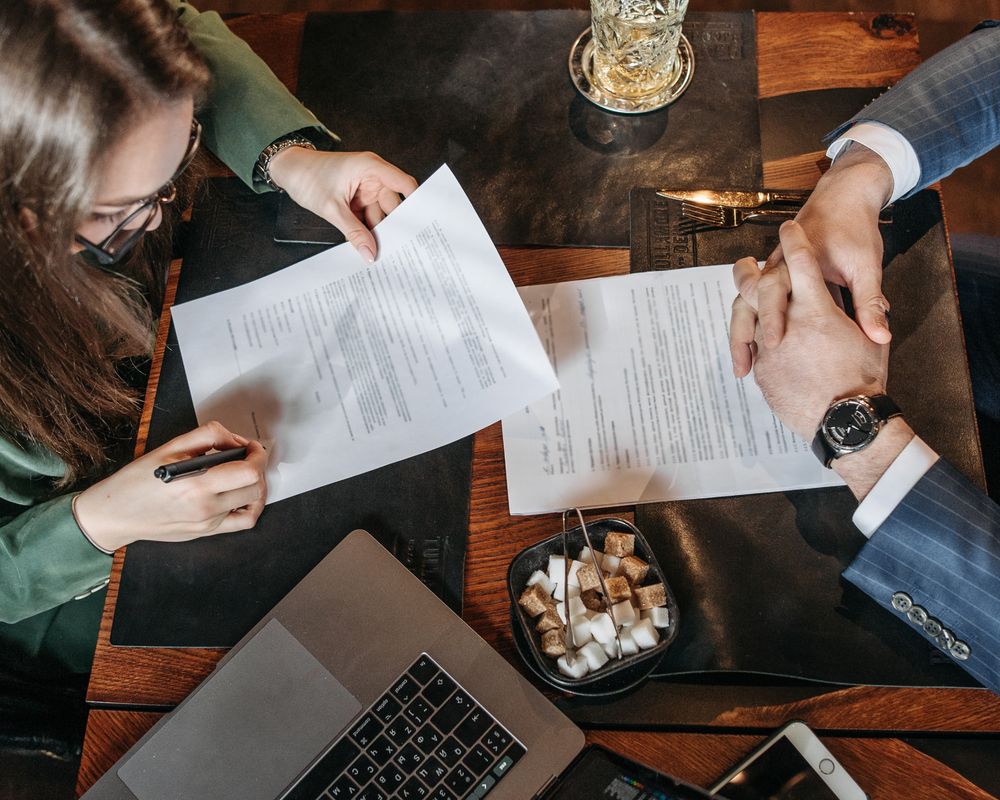 A person signing a document at a desk