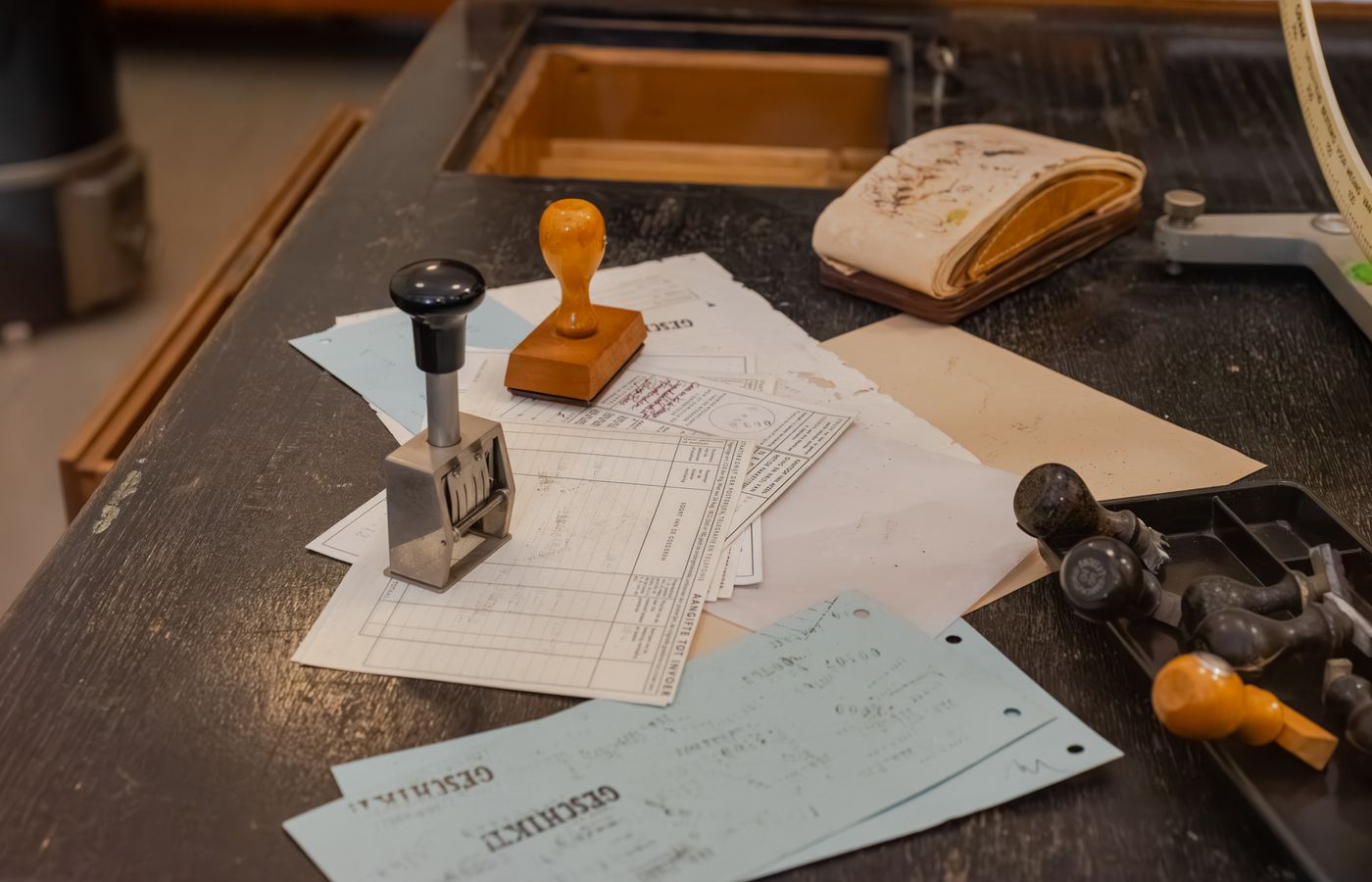 A cluttered desk covered in documents and stamps