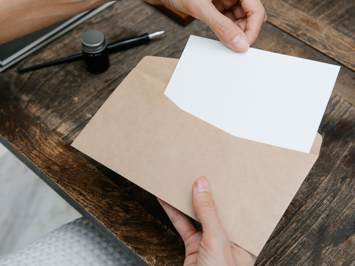 Hands placing a letter into an envelope